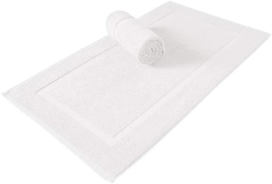 A white bath mat with a raised border, shown on a white background with a matching rolled towel placed on top.